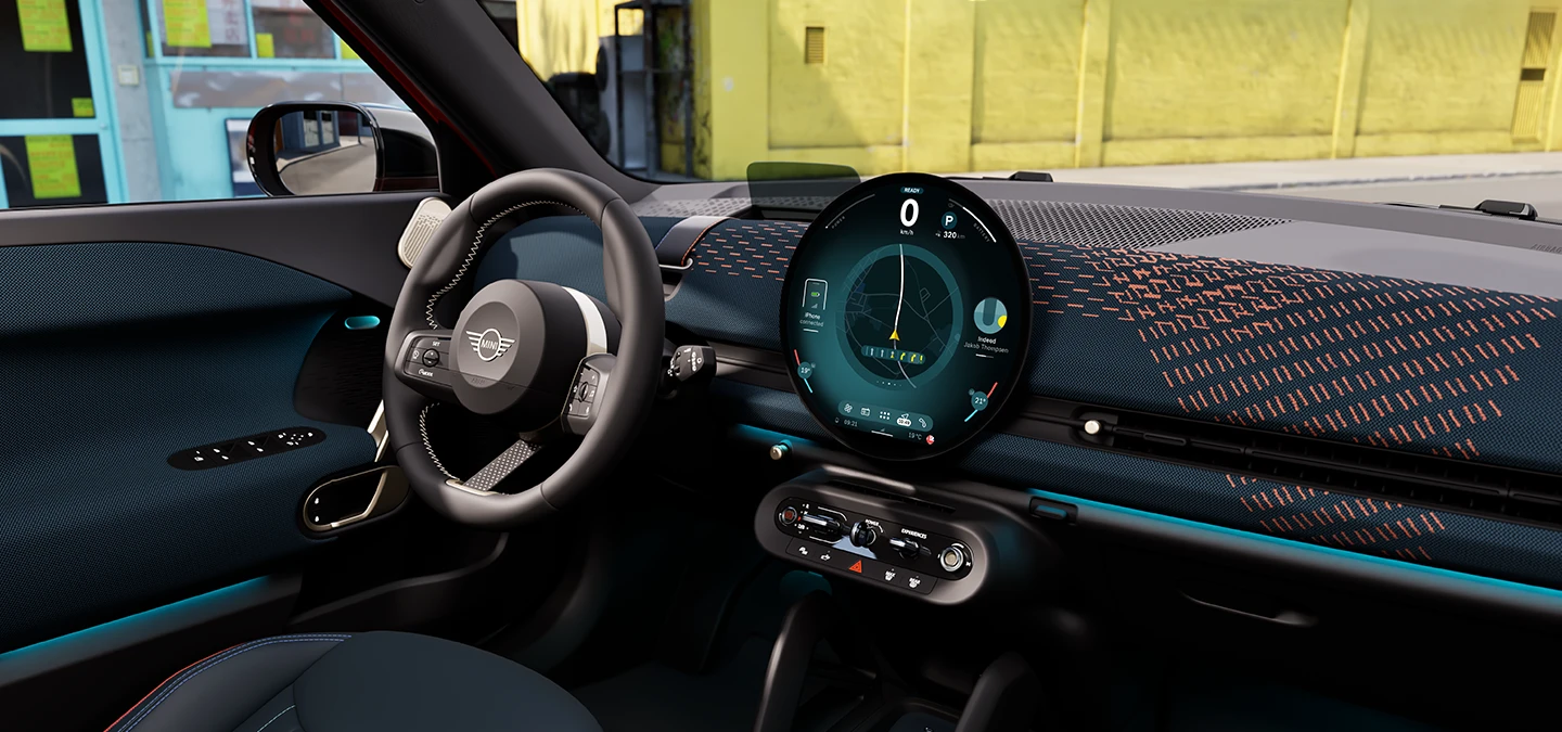 Interior view of the all-electric MINI Aceman focusing on the dashboard, the interaction unit and the steering wheel.