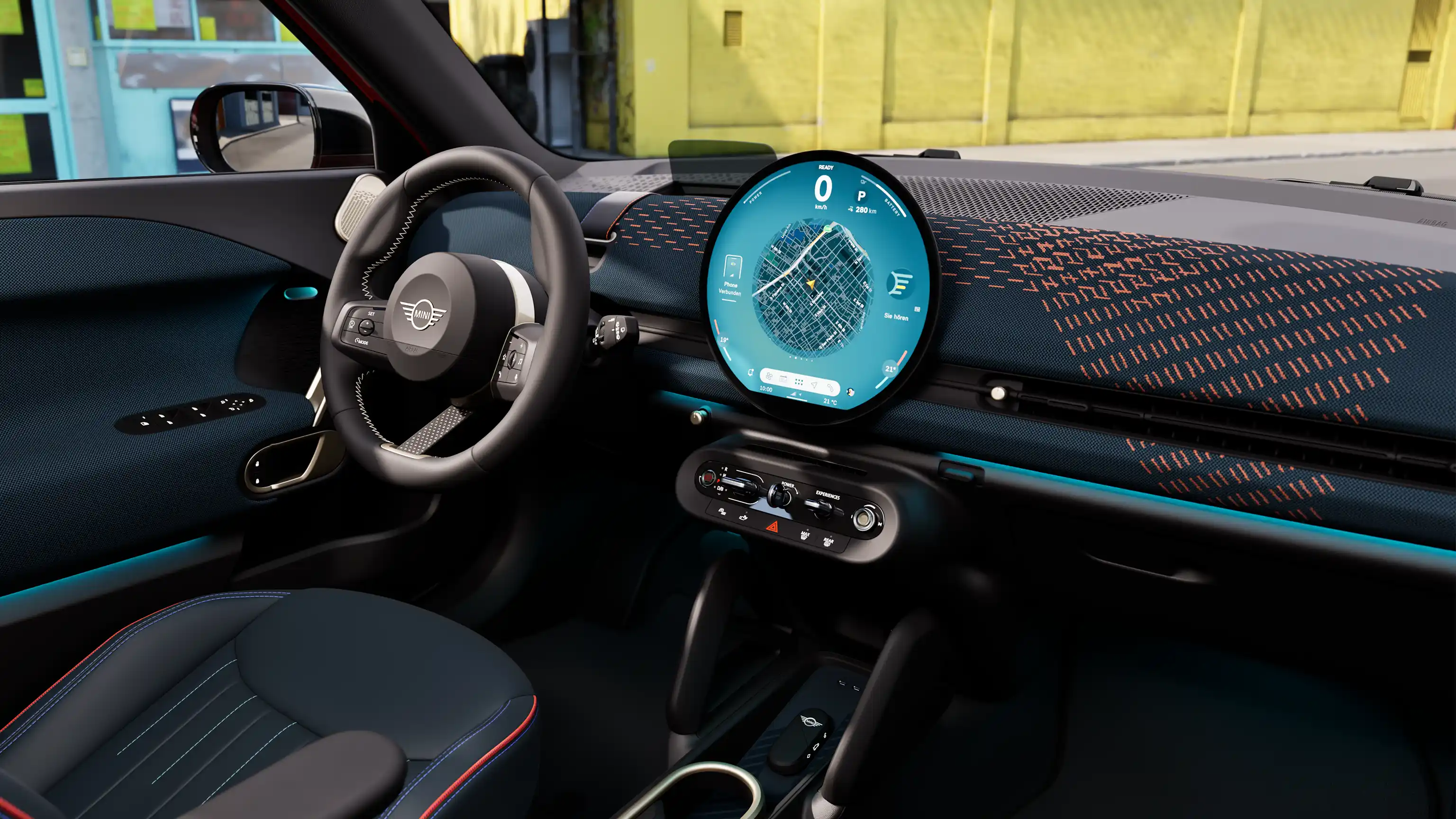 Panoramic view of the dashboard of the all-electric MINI Aceman with yellow wall in the background