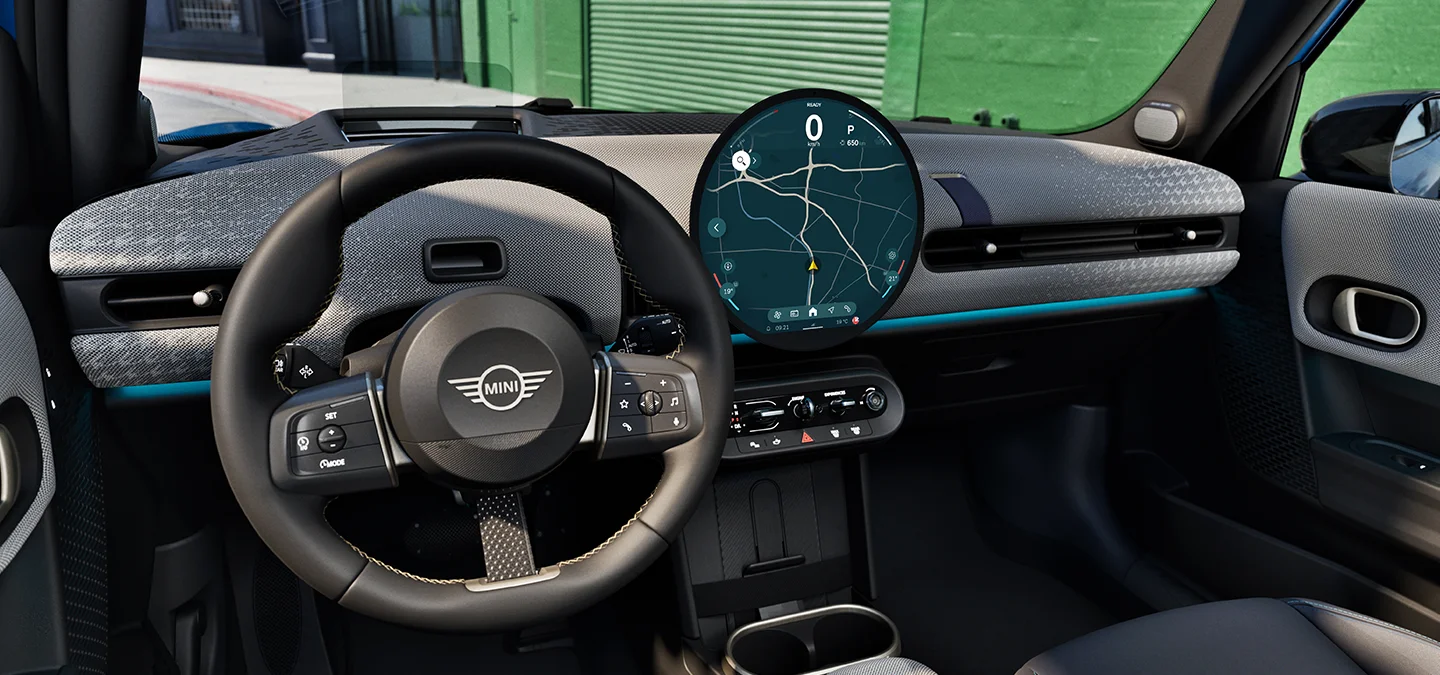 Interior view of the MINI Cooper 5-Door focusing on the steering wheel, the dashboard and the interaction unit.