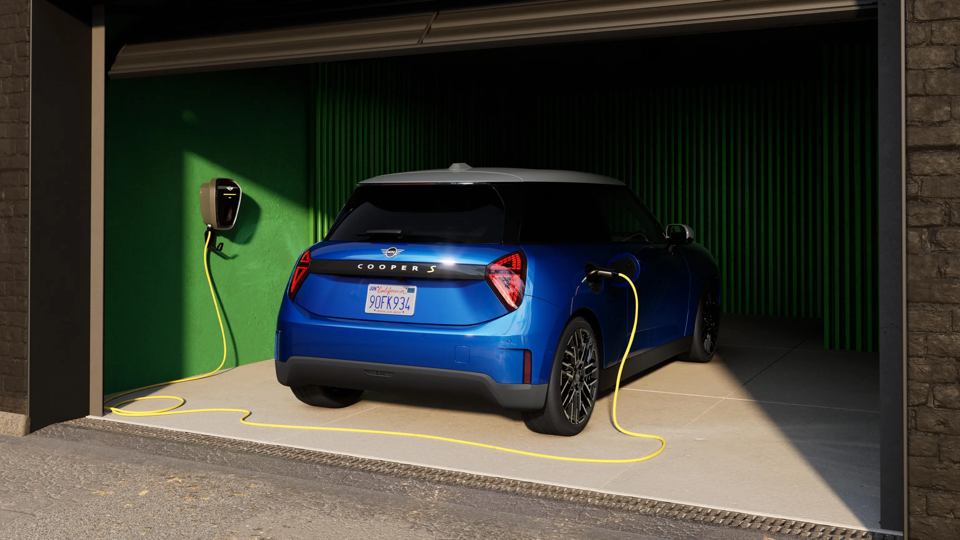 Rear view of Blazing Blue all-electric MINI Cooper in garage with charging cable