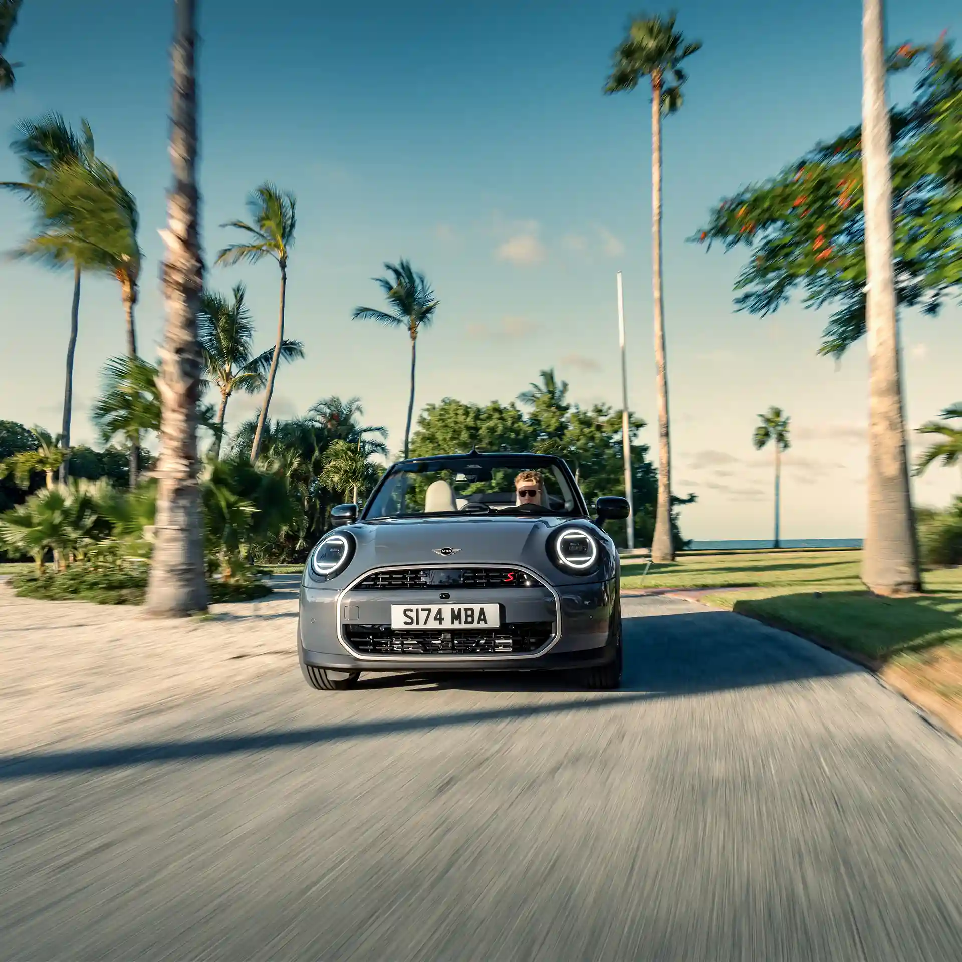 Frontal view of a driving MINI Cooper Convertible in Copper Grey on street