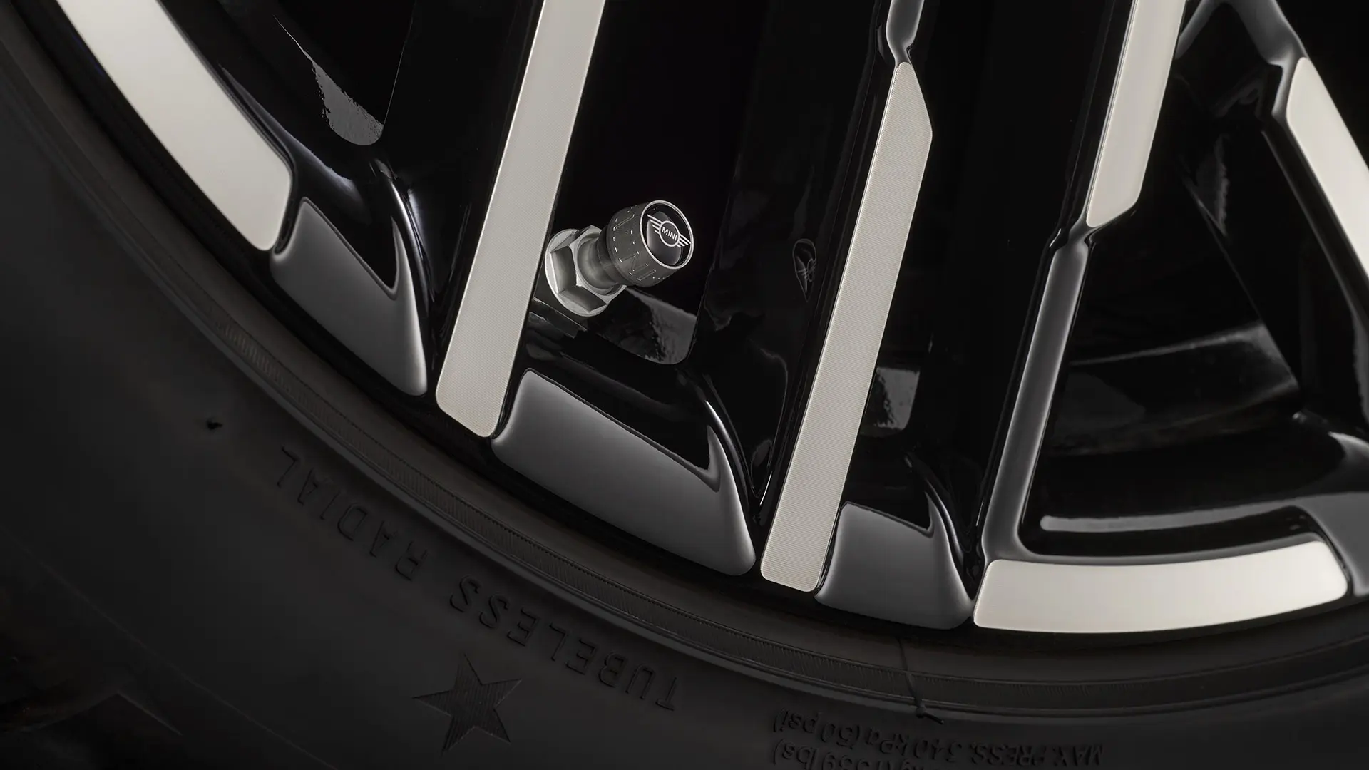 Close-up of black valve cap with the silver MINI wing logo.