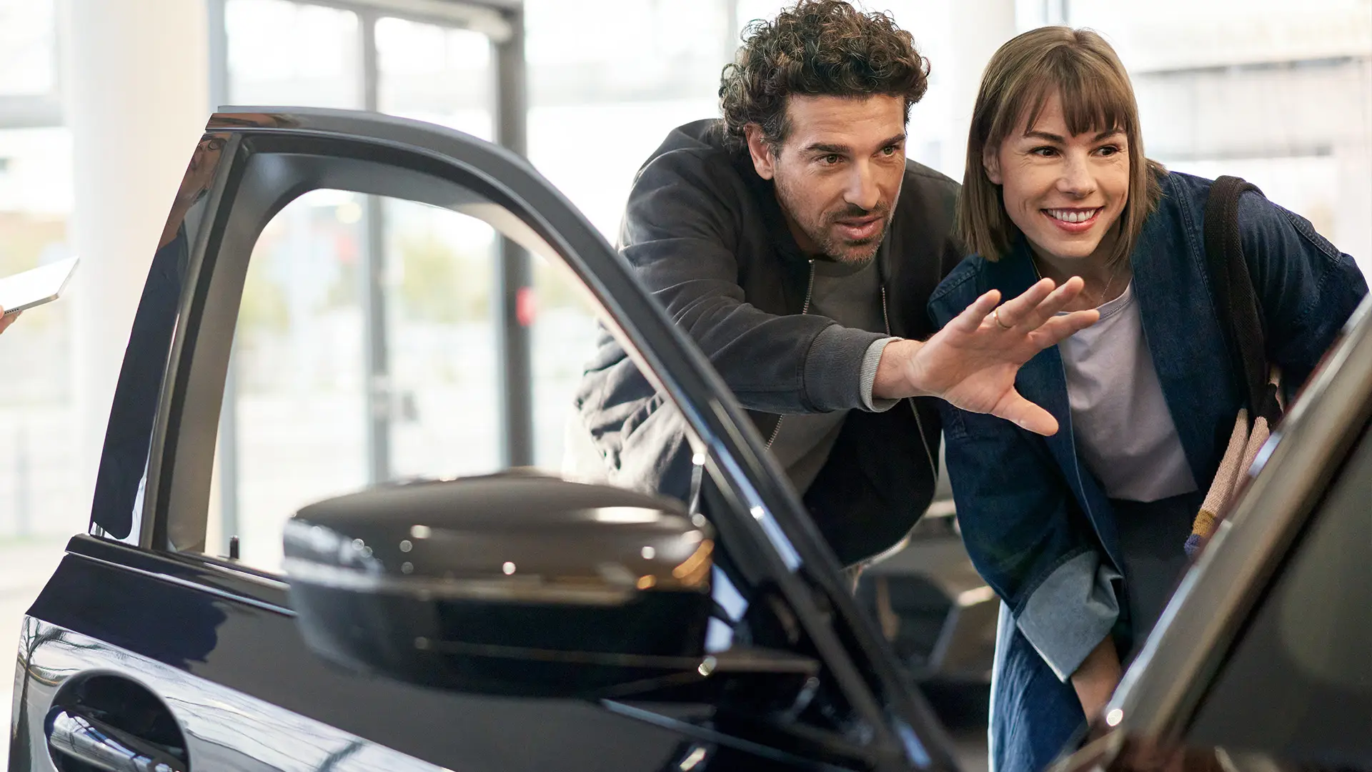 MINI inside MINI Centre with consultant advising customer and explaining interior features.