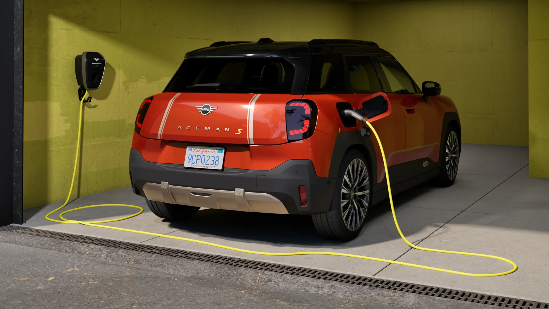 All-electric MINI Aceman S being charged with MINI Wallbox Plus, rear view, parked in garage.