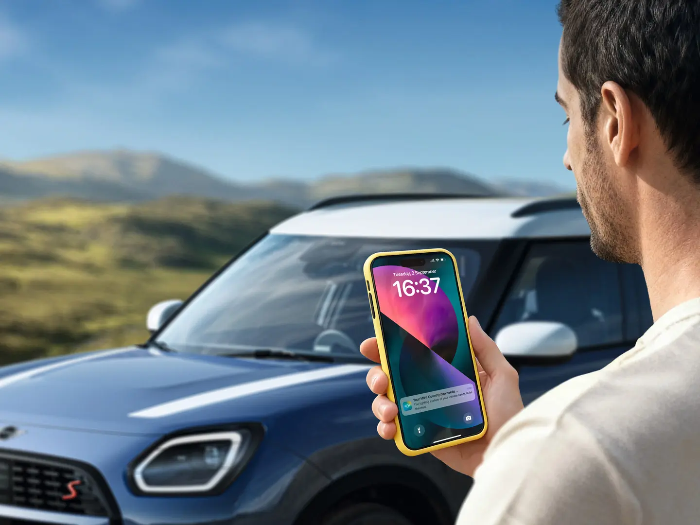 MINI Countryman driver using the MINI App to contact MINI Roadside Assistance. 