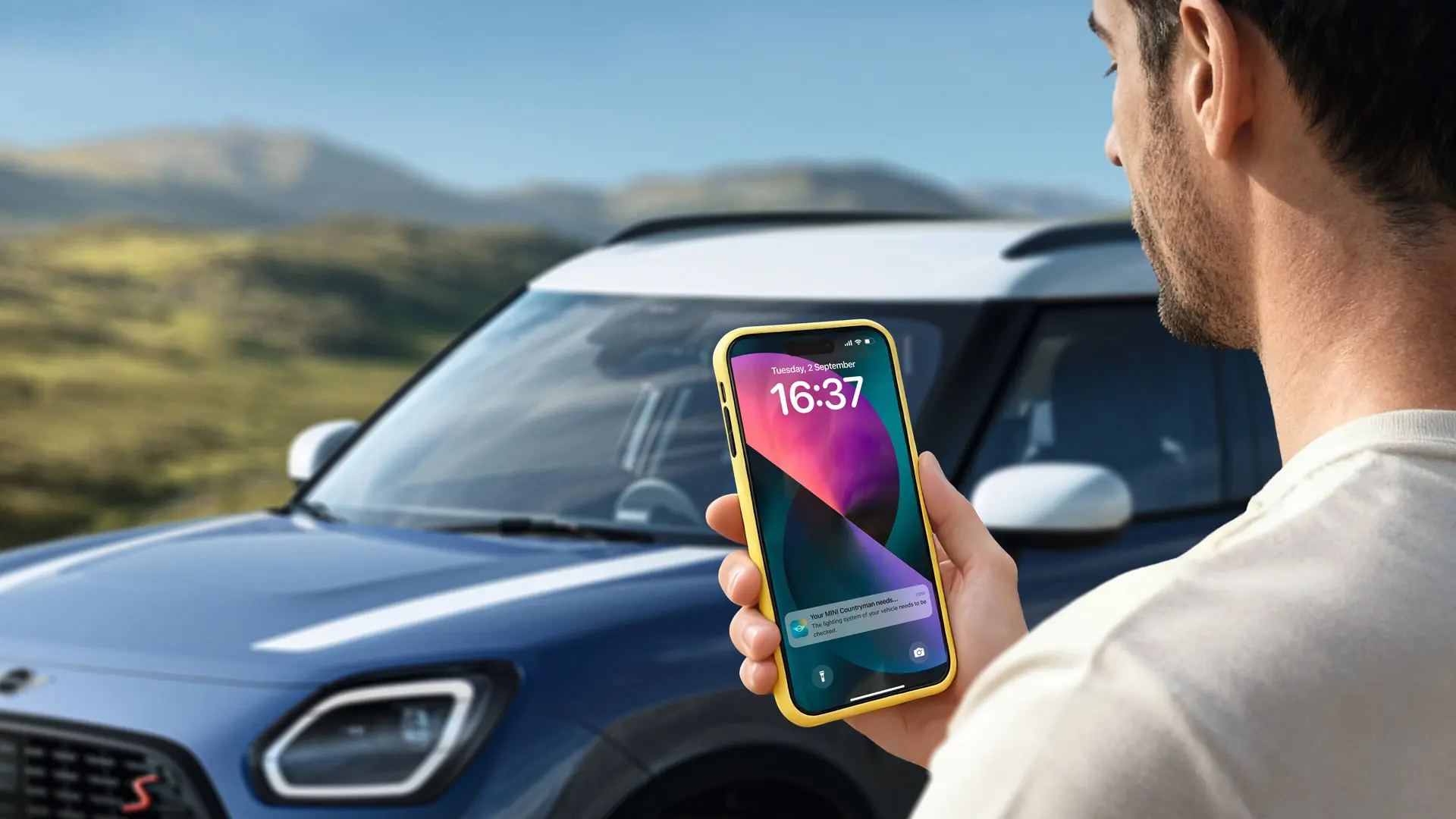 MINI Countryman driver using the MINI App to contact MINI Roadside Assistance. 