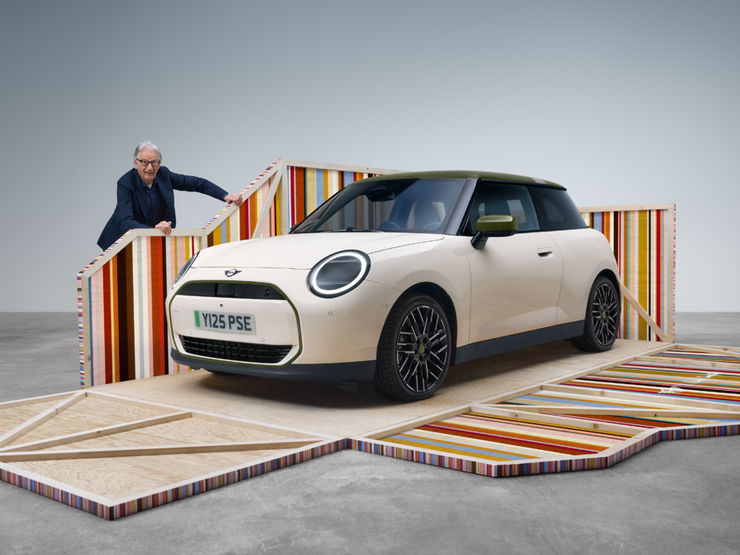 Front side view of the all-electric MINI Cooper Paul Smith Edition in Inspired White with designer Paul Smith