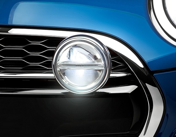 Front of blue car showing headlights.