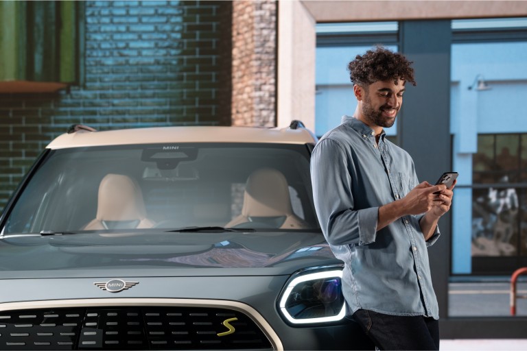 MINI front view, detail, with man leaning against MINI