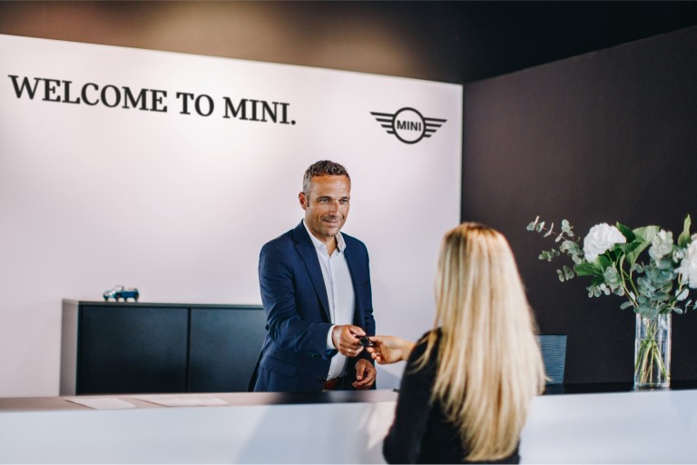 MINI partner welcome desk with employee and customer