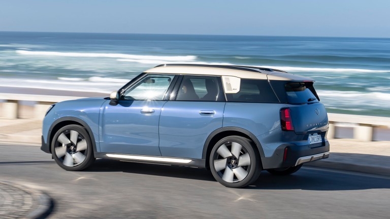 all-electric MINI Countryman side view driving with sea in background
